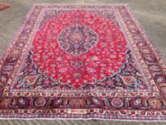 A Mashad wool carpet
The wine red field enclosing a central medallion with pendant palmettes