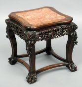 A late 19th century Chinese carved hardwood urn stand
The marble inset top above pierced scrolling