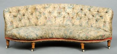 A Victorian upholstered button back settee
Of curved shape with floral upholstery, standing on