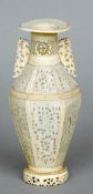 A 19th century Cantonese carved ivory vase
Of baluster form with twin pierced scrolling handles