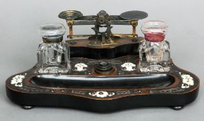 A Victorian desk stand
The brass mounted main body with a pen tray, inkwells, scales and weights,