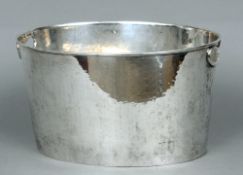 A silver plated ice bucket
Of beaten oval form with twin pierced handles.  35 cms wide.