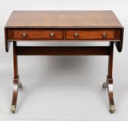 A Regency style mahogany sofa table
The twin flap rounded rectangular top above a pair of frieze