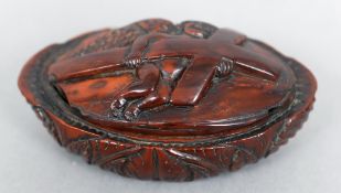 A 19th century coquilla nut snuff box
The hinged oval lid carved with an angel carrying a cross.
