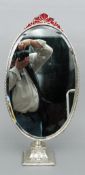 A large Victorian oval swing mirror, hallmarks indistinct
The pierced ribbon headed oval silver