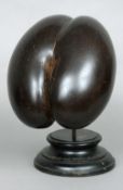 A coco de mer
Of typical form, mounted on a detachable turned wooden display stand.  25 cms
