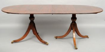 An 18th century style twin pillar dining table
The oval top incorporating an additional leaf, the