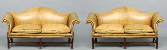 A pair of leather upholstered camel back settees
Each with pale green studded leather upholstery