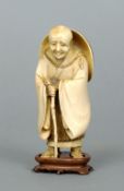 A 19th century carved ivory figure
Modelled as an elderly bald gentleman with a walking stick and