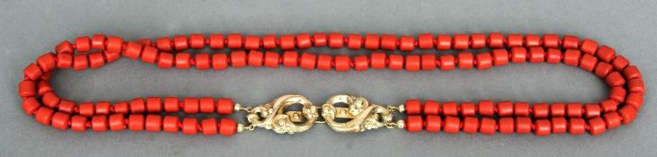 An unmarked gold mounted coral necklace
Set with a pierced scrolling clasp.  52 cms long.