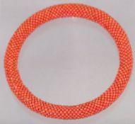 A coral set bangle
Formed from small coral beads.  9.25 cms diameter.   CONDITION REPORTS: