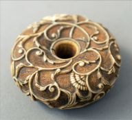 A 19th century Chinese carved ivory roundel The pierced centre bordered by floral scrollwork. 5.5