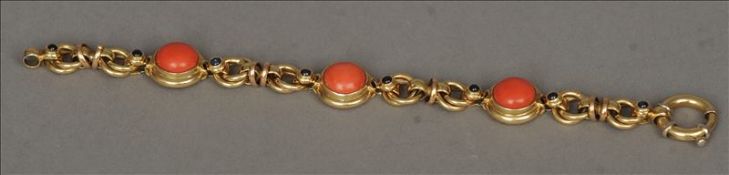 An 18 ct gold bracelet Set with cabochon, coral and sapphires. 19 cms wide. Generally in good