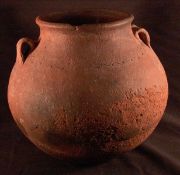 An Antique pottery twin handled pot Of rounded form with loop handles and incised band decoration.