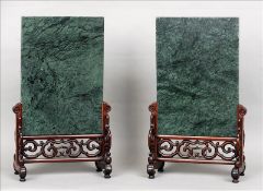 A pair of Chinese table screens Each variegated marble panel standing on a pierced and carved