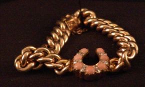 A 15 ct rose gold curb link bracelet Inset with a diamond and coral horseshoe. Generally in good