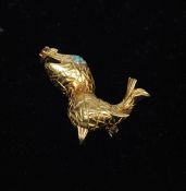 A French 18 ct gold brooch Formed as a sea lion with an inset diamond and emerald eye and a ruby