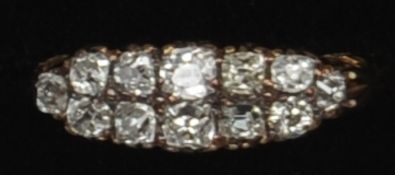 An Edwardian unmarked 18 ct gold navette ring Set with two rows of diamonds above scrolling