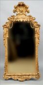 An 18th century carved giltwood pier glass The two part plate bordered by the scroll carved frame