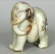 A Chinese carved pale and russet jade elephant Naturalistically modelled, standing four square,