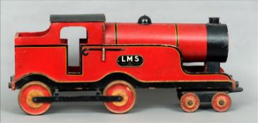 A 1930s Lines Brothers painted wooden model locomotive In red and black livery with a tin plate