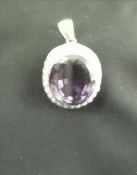 An unmarked yellow metal amethyst and seed pearl pendant The central facet cut amethyst with a