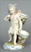 A 19th century Continental porcelain figural spill vase Modelled as a putto carrying floral