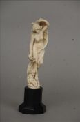 A 19th century Dieppe carved ivory figural group Modelled as a naked lady holding a flowing robe and