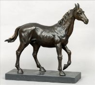 A bronze model of a horse Naturalistically modelled, standing on a black marble plinth base. 44