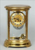 A late 19th century French oval four glass mantel clock The lacquered brass case enclosing the