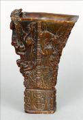 A Chinese carved horn libation cup Carved in the round with mythical beasts. 13.5 cms high. Some