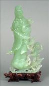 A Chinese carved jade figural group Formed as Guanyin, modelled holding a ruyi sceptre with a