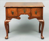 An 18th century style walnut lowboy The cross banded rectangular top above an arrangement of three