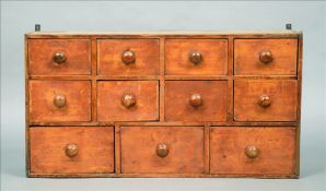 A 19th century painted pine bank of drawers Comprising and arrangement of eleven variously sized