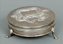 A Chinese silver trinket box The circular hinged lid embossed with a dragon, standing on three