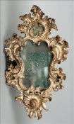 An 18th/19th century Venetian carved wooden wall glass The scroll carved frame with silvered