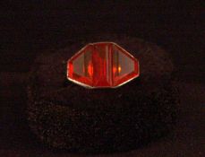 An Art Deco unmarked white metal fire opal set ring The central baguette cut stone flanked by two