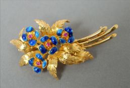 An 18 ct gold and enamel decorated floral spray brooch The enamel flowers set with small ruby chips.