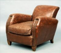 An Art Deco leather upholstered armchair Upholstered in tan leather, the curved back and arms