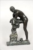 After the Antique A 19th century bronze figure modelled as Hermes fastening his sandal. 37 cms high.