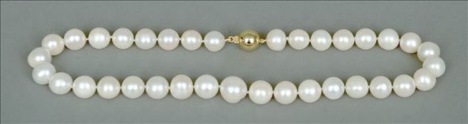 A pearl necklace mounted with a 14 ct gold clasp 35 cms long. Some pitting, scratching/surface