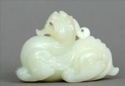 A Chinese carved jade model of a dragon Carved in recumbent position. 8 cms wide. Fritting/chipping,