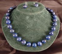 A lapis lazuli bead necklace and a pair of matching earrings The former 48 cms long. (2) Overall