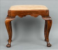 An early 20th century Sandringham School of Carving walnut stool The padded drop-in seat above a