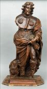 A 17th century carved walnut figure Modelled standing in flowing robes, mounted on a later plinth