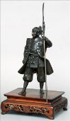 A Japanese Meiji period patinated bronze model of a Samurai warrior Modelled standing in ornately