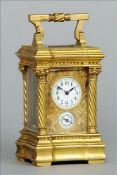 A 19th century miniature gilt brass cased carriage alarm clock The angular swing handle above