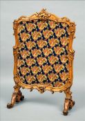 A Victorian carved oak fire screen The shell headed scroll carved frame with an inset floral