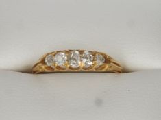 An unmarked gold and diamond five stone ring Set in pierced shoulders above a plain shank. General