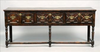 An 18th century oak low dresser The planked rectangular top above three geometrically moulded frieze